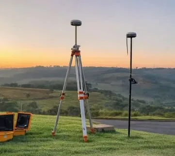 Receptores GNSS da Topoagro montados em tripé no campo ao pôr do sol